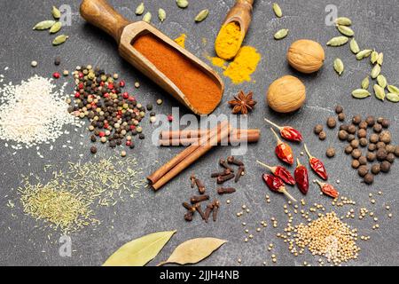 Set of dry spices on table. Ground paprika in wooden scoop. Top view. Black background Stock Photo