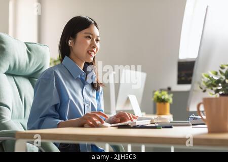 Happy Asian Millennial Businesswoman Working Online On Computer In Office Stock Photo