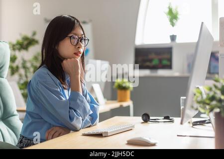 Korean Businesswoman Working Online On Computer Browsing Internet In Office Stock Photo