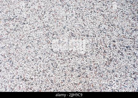 Mixed small gray broken rocks, loose gravel, road construction. Limestone aggregate. Crushed stone background Stock Photo