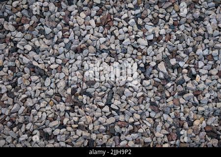 Mixed small gray broken rocks, loose gravel, road construction. Limestone aggregate. Crushed stone background Stock Photo