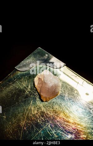 rose quartz on brass iridescent table with black background Stock Photo
