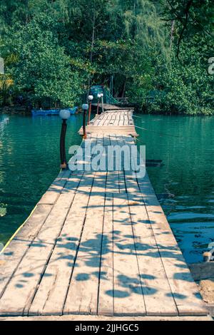 wooden bridge over the river in the tropical jungle in Asia, atmospheric place Stock Photo