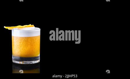 whiskey sour cocktail served on the rocks isolated on a black background garnished with an orange slice Stock Photo