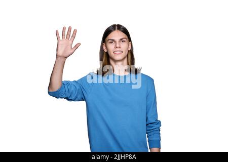 Young guy looking at camera waving his hand, on white isolated background Stock Photo