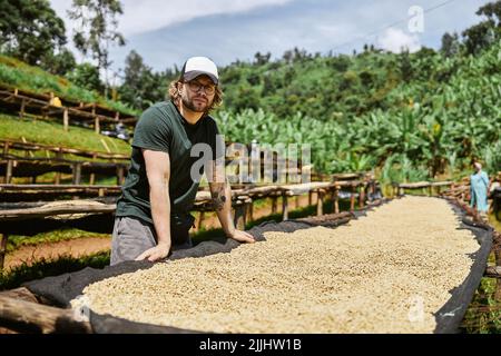 Guy in cap standing near coffee washing station Stock Photo