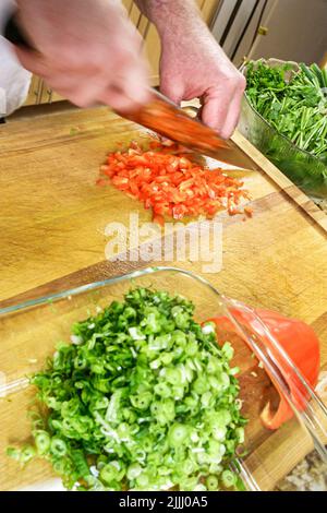 Florida Kendall,Hispanic Latin Latino ethnic immigrant immigrants minority,adult man male,chef makes how to cook video,kitchen cutting red pepper Stock Photo