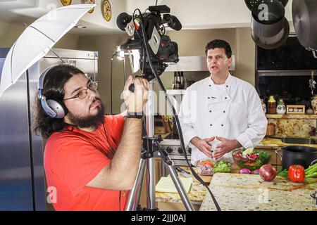 Florida Kendall,Hispanic Latin Latino ethnic immigrant immigrants minority,adult man male,chef makes how to cook video,kitchen cutting videographer Stock Photo