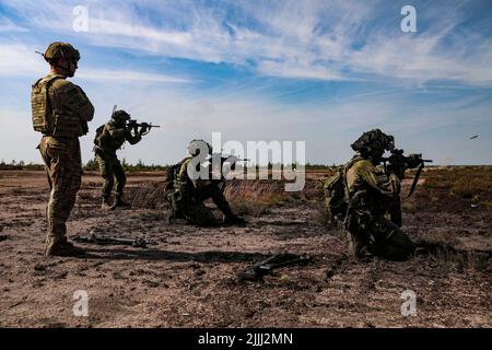 Finnish soldiers assigned to the Satakunta Jaeger Battalion, fire M4A1 carbines under supervision of a U.S. Soldier assigned to 3rd Armored Brigade Combat Team, 4th Infantry Division at Niinisalo, Finland, July 21, 2022. The 3/4th ABCT is among other units assigned to the 1st Infantry Division, proudly working alongside NATO allies and regional security partners to provide combat-credible forces to V Corps, America's forward deployed corps in Europe. (U.S. Army photo by Sgt. Andrew Greenwood) Stock Photo
