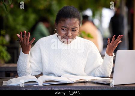 I dont understand. a young woman looking stressed while studying in a cafe. Stock Photo