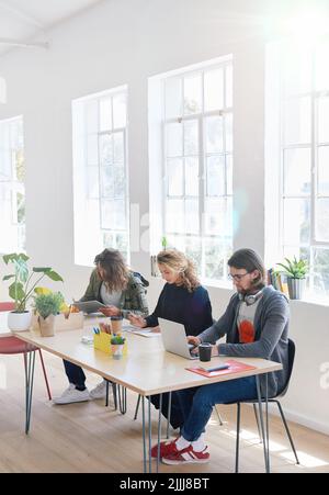College students sitting at table in class working on project Stock Photo