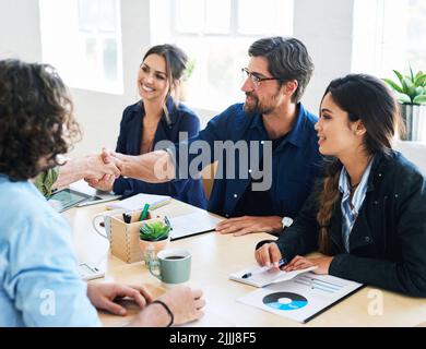 Business people shaking hands in office meeting after successful partnership deal for startup company Stock Photo