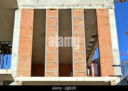 red brick column wall in sunny day, modern building site diversity Stock Photo