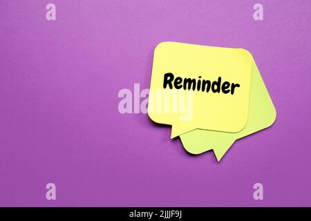 Sticky note with text REMINDER on violet background Stock Photo