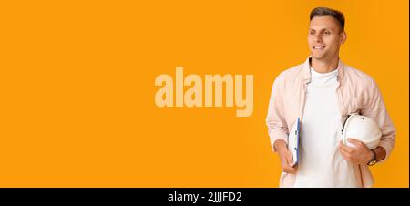 Young male architect with hardhat on yellow background with space for text Stock Photo