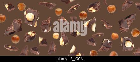 Falling pieces of chocolate with hazelnuts on brown background Stock Photo