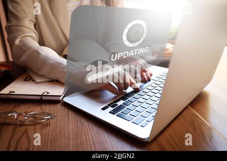 Young woman updating laptop software Stock Photo