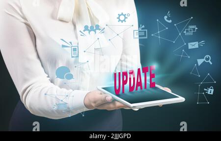 Businesswoman with tablet computer on dark background. Concept of update Stock Photo