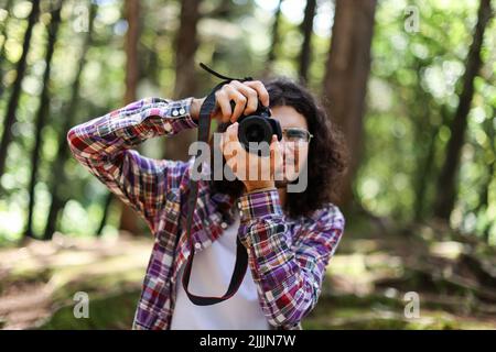 Young Latin Photographer taking picture of you in the forest at Costa Rica Stock Photo