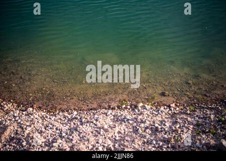 Porta Westfalica, Germany. 27th July, 2022. View into the water of the gravel pond where two people failed to surface on Sunday (24.07.2022) for unexplained reasons while bathing. According to a spokesman for the fire department, some parts of the lake are 30 meters deep. Experts from the police will now search for the two people with an underwater probe. Credit: Lino Mirgeler/dpa/Alamy Live News Stock Photo