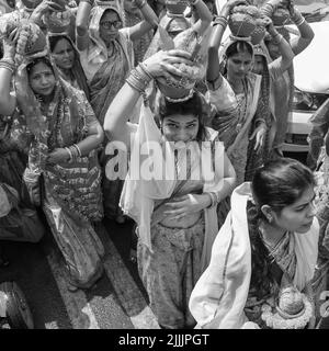 Delhi, India April 03 2022 - Women with Kalash on head during Jagannath Temple Mangal Kalash Yatra, Indian Hindu devotees carry earthen pots containin Stock Photo