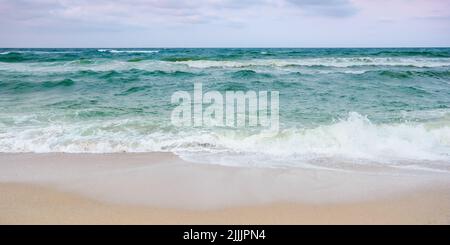 stormy weather in velvet season. seascape with clouds in evening light. waves crashing sandy beach. windy weather Stock Photo