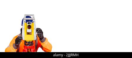 A builder in a blue helmet, orange reflective hi-visibility fleece and safety gloves on white background with space for text using modern surveying eq Stock Photo