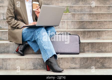 woman works outdoors with her laptop computer Stock Photo