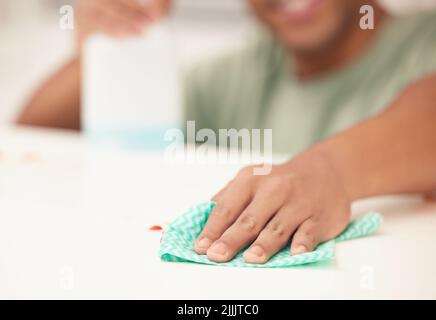Getting every single dust mite. a man cleaning a kitchen counter. Stock Photo