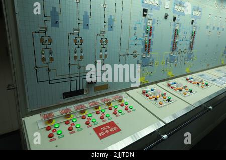 ship engine room dashboard with plenty of bottoms, indicators, small indication lamps and schematics of engines and generators, voltmeters, amperemete Stock Photo