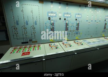 ship engine room dashboard with plenty of bottoms, indicators, small indication lamps and schematics of engines and generators, voltmeters, amperemete Stock Photo