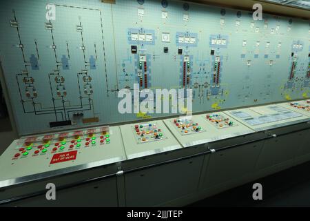 ship engine room dashboard with plenty of bottoms, indicators, small indication lamps and schematics of engines and generators, voltmeters, amperemete Stock Photo