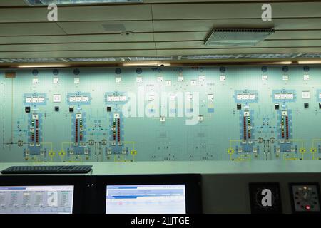 ship engine room dashboard with plenty of bottoms, indicators, small indication lamps and schematics of engines and generators, voltmeters, amperemete Stock Photo