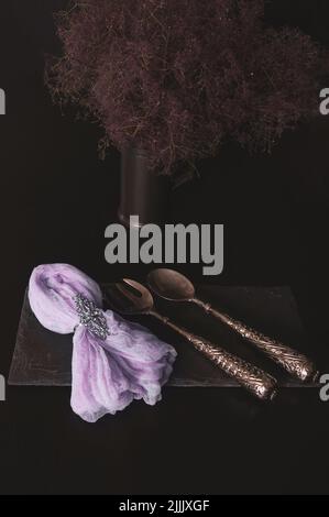 Bouquet of lavender on a black board made of raw stone with a napkin on a dark background Stock Photo