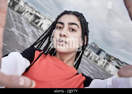I take pride in my street style. Cropped portrait of an attractive young female dancer taking a selfie while standing on a rooftop against a stormy Stock Photo
