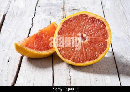 Fresh grapefruit slices on wooden table Stock Photo