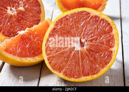 Fresh grapefruit slices on wooden table Stock Photo