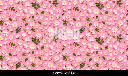 Seamless floral pattern of rose flowers, leaves buds and heart shaped petals on pink background top view flat lay Stock Photo