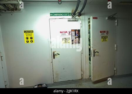 Cruise ship engine room interior with water tight doors electrical and diesel engines, water pipes, measuring instruments, warning signs Stock Photo