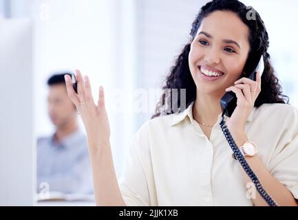 Selling is her strong point. a young businesswoman talking on a telephone while working in an office. Stock Photo