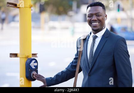 Always be cautious. a young businessman pushing a traffic light button in the city. Stock Photo