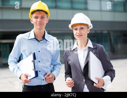 Portrait of smiling architectors who standing with folder and laptop Stock Photo