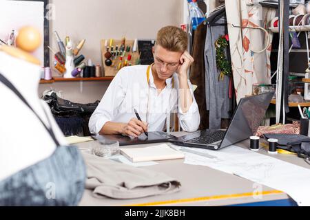 Tailor creating pattern using laptop Stock Photo