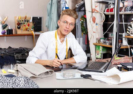 Tailor creating pattern using laptop Stock Photo