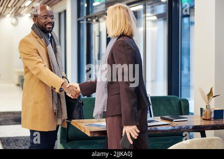 Two lawyers greeting and smiling to each other while having a business meeting in courtroom Stock Photo