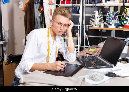 Tailor creating pattern using laptop Stock Photo