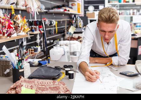 Tailor creating pattern on table Stock Photo