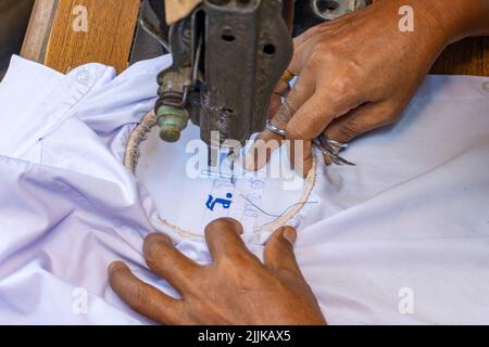 Embroidering Thai numbers on a student's shirt on an old sewing machine Stock Photo