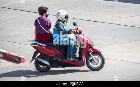 SAMUT PRAKAN, THAILAND, MAY 26 2022, A taxi driver on a motorcycle rides with a woman. Stock Photo