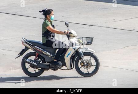 SAMUT PRAKAN, THAILAND, MAY 26 2022, A woman with face mask rides a motorcycle Stock Photo
